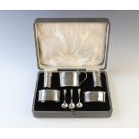 A cased silver cruet set, comprising mustard pot, pepperettes and open salt by Deakin & Francis,