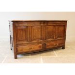 A George III oak mule chest, the hinged cover above four invert moulded panels and two drawers,