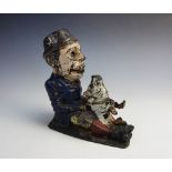 A 19th century metal money box, modelled as a seated man with a pig between his legs, the pig's