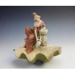 Three Royal Dux figures comprising: a girl collecting water above a large half clam shell, pink