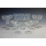A part suite of glassware, each piece of faceted form with continuous band of scrolling foliate