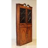 A George III oak free standing corner cupboard, with broken swan neck pediment above a pair of