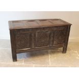 An 18th century oak coffer, with three panel front and carved detail, integral candle box and on