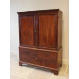 A 19th century mahogany linen press, the moulded cornice above a pair of panelled doors enclosing