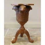 A carved oak occasional table, 20th century, designed as three eagle's masks, above a trefoil top,