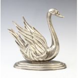 A white metal brandy warmer in the form of a swan, on stepped base with central burner and