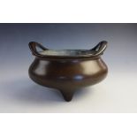 A Chinese bronze censer, Xuande mark, of compressed form with openwork slender lug handles, raised