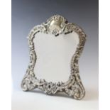 An Art Nouveau silver mounted mirror by Henry Matthews, Birmingham 1902, the shaped border with
