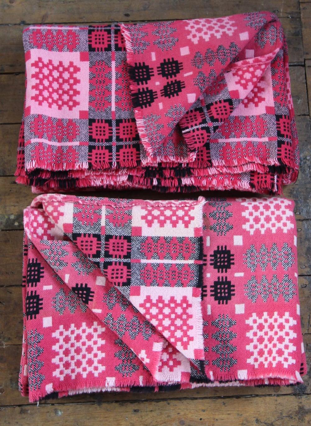 A pair of Welsh blankets, of traditional reversible geometric design in washed red, pink and