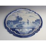 An 18th century style Delft blue and white tin glazed earthenware wall plaque, of moulded oval