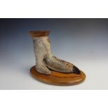 A taxidermy Ostrich foot ash tray, upon an oval wooden plinth base, 20cm high