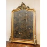 A late 19th century French giltwood overmantel mirror, set with a bevelled mirror plate with