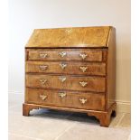 A mid 18th century figured walnut bureau, the veneer fall front enclosing a central door flanked