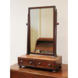 A George III mahogany dressing table mirror, the rectangular mirror plate on channelled uprights and