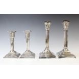 A pair of silver plated candlesticks, each designed as a reeded column with palm leaf wrapped