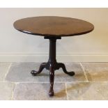 A George III mahogany tripod table, the circular top mounted upon a birdcage movement and a ring