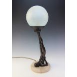 An Art Deco style bronzed figural lamp base, modelled as a nude figure supporting a spherical