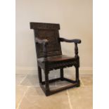 A 17th century and later Wainscot chair, the foliate carved back board above a board seat and shaped