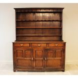 A George III oak North Walian dresser, the enclosed high back with three shelves above an