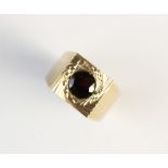 A garnet set 9ct gold ring, Birmingham 1971, the central circular garnet within a square panel, with