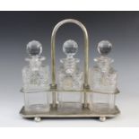 A three bottle tantalus, comprising three cut glass decanters, each approx. 23cm high, each with a