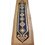 A geometric wool runner, with central medallions in a nomadic design, in blue, brown, oatmeal and