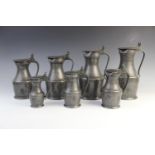 A graduated set of seven pewter lidded flagons, 18th/19th century, each with acorn moulded thumb