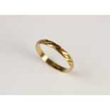 A yellow metal ring, with engraved twist detail, stamped '750', size X, weight 2.2gms