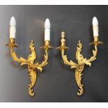 A pair of French ormolu Rococo style twin branch wall light fittings, cast as intertwined foliate