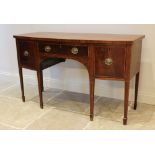 A George III mahogany bow front sideboard, the central drawer flanked by two deep drawers, raised on