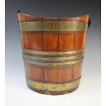 A George III coopered brass bound mahogany peat bucket, of typical sunken oval form, lacking handle,