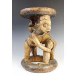 A West African Cameroon Grassland wooden stool with two figures wrestling, 39cm high