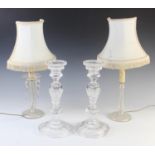 A pair of early 20th century candlesticks, with baluster columns raised upon a spreading circular