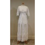 A cotton afternoon dress, circa 1915, the white dress decorated with broderie anglaise in floral and