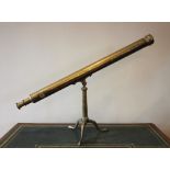 A brass telescope, late 19th/early 20th century, mounted on a tapering brass column with hinged