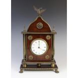 A 19th century Regency mahogany cased architectural mantel timepiece of ogee form, the 9cm white