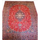 A large washed red ground Persian Tabriz carpet, with a floral medallion design, 380cm x 293cm