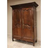 A large 18th century French chestnut armoire, the stepped cornice incised with trailing vines, above