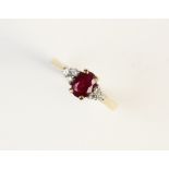 A ruby and diamond 9ct gold ring, the central oval mixed cut ruby measuring 7mm x 5mm, with three