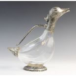 A novelty claret jug, modelled as a duck with faceted glass body and white metal mounts, the spout