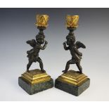 A pair of candlesticks, each with figural stem modelled as a cherub upon chequered base and marble