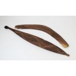 A large Australian Aboriginal spear thrower with carved decoration, 83cm long, along with a