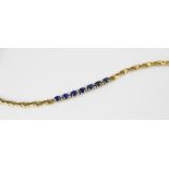 A sapphire doublet and diamond set line bracelet, comprising seven oval mixed cut sapphire doublets,