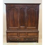 An 18th century oak livery cupboard, the moulded cornice above a pair of fielded panelled cupboard