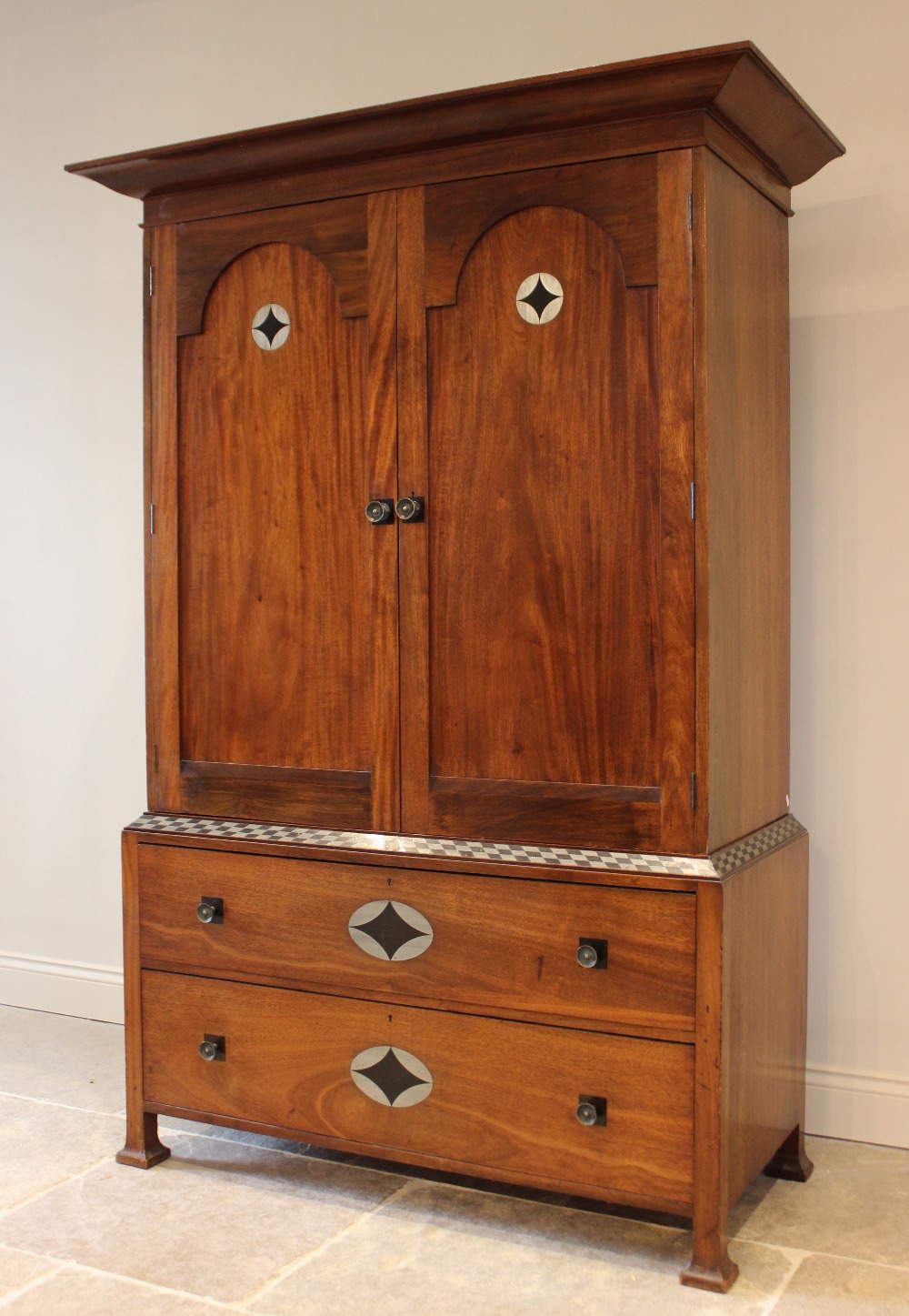 An early 20th century mahogany Arts & Crafts linen press, in the manner of Ambrose Heal, the cavetto