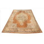 A large Turkish wool carpet, in orange and cream colourways with a larger central medallion, 406cm x