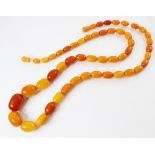 A butterscotch amber bead necklace, comprising fifty-one graduated plain polished oval beads