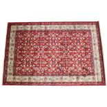 A full pile rich red ground Kashmir all-over floral pattern design surrounded by a gold border,