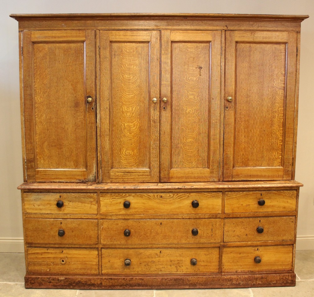 A Victorian scumbled pine housekeepers cupboard, the moulded cornice above four invert panelled