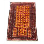 A hand woven full pile Afghan Baluchi Nomadic prayer rug, with an orange ground, 128cm x 81cm